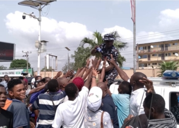 Image showing NLC Protesters recieving items shared by Police during the protest.