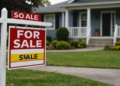 House with 'For Sale' sign in front yard