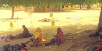 residents receiving drip under a tree