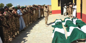 Some military men praying for the Metele fallen heroes before their burial, in Maiduguri on Friday