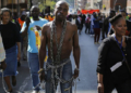 A man wearing chains walks with thousands of others during a march calling for an end to attacks against foreign nationals in Johannesburg, South Africa