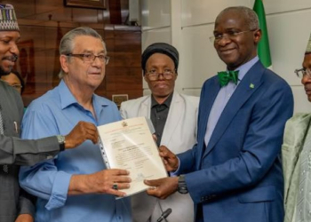 Super Eagles’ coach, Clemens Westerhof receiving documents of his house gift