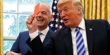 U.S. President Donald Trump holds up a red card as he meets with FIFA President Gianni Infantino in the Oval Office of the White House in Washington, U.S.