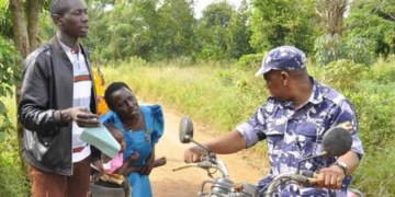 Woman kneels down begging police officers not to confiscate motorcycle of a rider carrying sick child